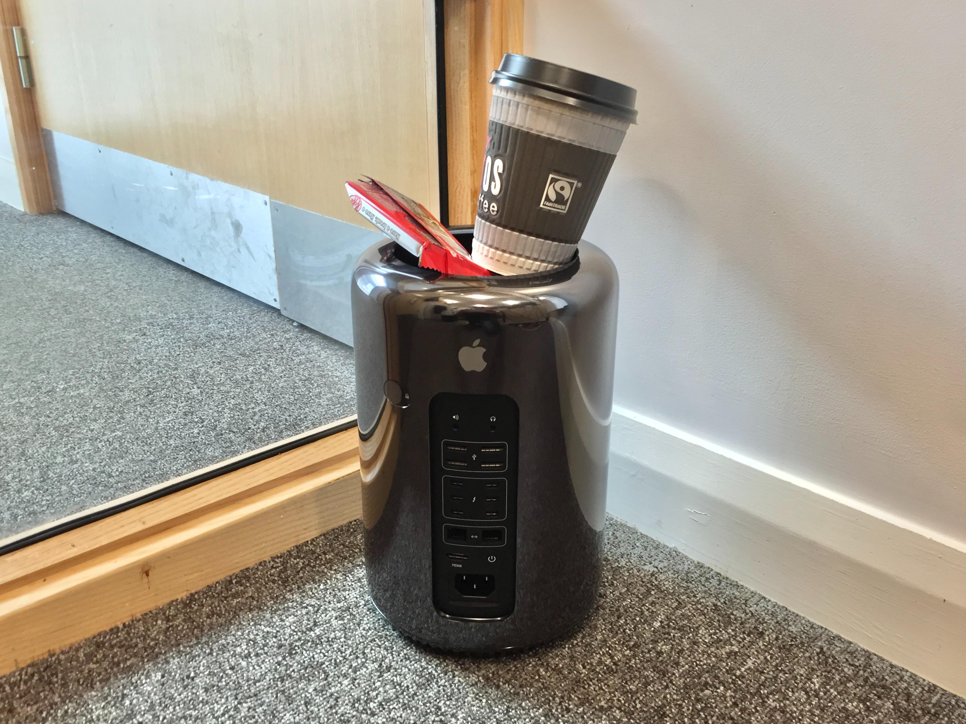 Photograph of a Mac Pro (2013) on the floor in the corner of a room, with an empty KitKat wrapper and coffee cup perched on top. This was known as the "trash can" Mac, so I thought I'd be amusing.