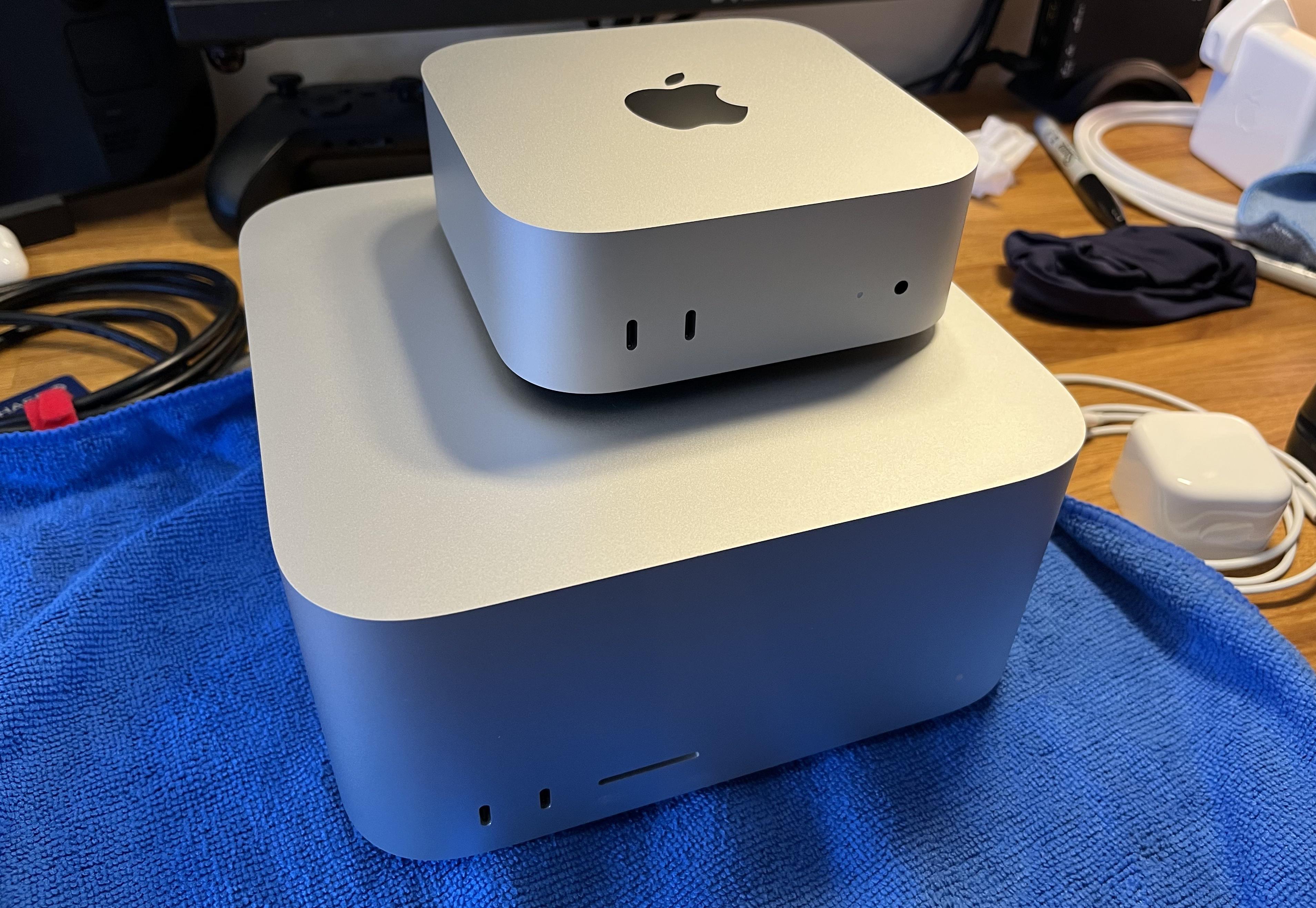 A Mac mini (2024) sat on top of a Mac Studio (2023). One is 5 cm tall, 12.7 cm square when viewed from the top, and weighs 670 g. The other is 9.5 cm tall, 19.7 cm square, and weighs 2700 g. It has an oddly proportioned front which makes it appear to have a huge forehead, like Dec, of Ant & Dec fame.